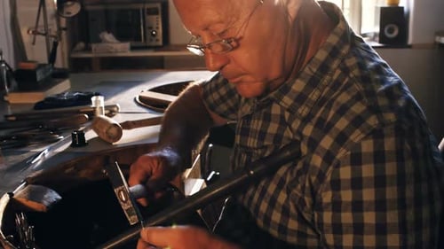 Senior Craftsman Working on Metal in Workshop