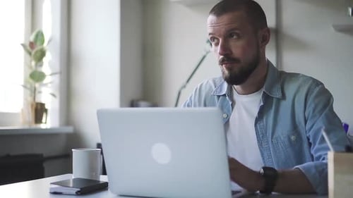 Adult Man Using Laptop in Bright Office