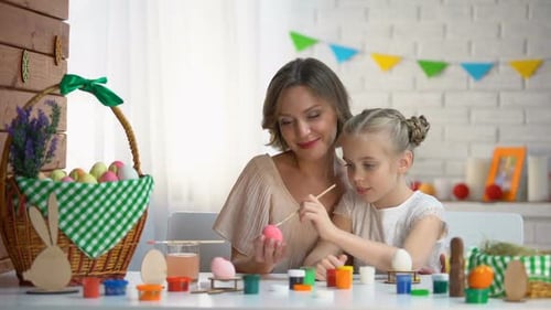 Little Girl Trying to Paint Easter Egg Loving Mother Helping and Supporting Her
