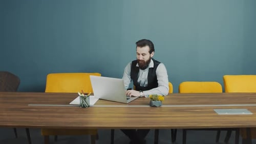 Man Works on Laptop in Modern Office