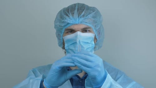 Medical Worker Inspecting Syringe in Sterile Environment