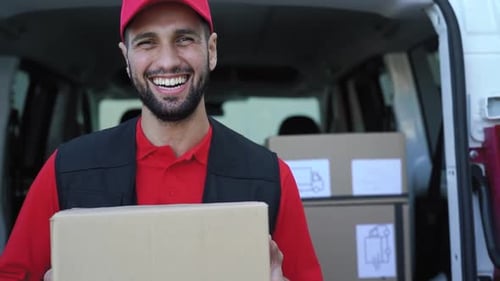 Jeune livreur transportant une boîte en carton - Les personnes travaillant avec un transport rapide