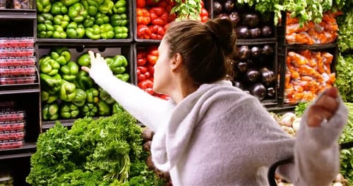 Woman buying capsicum in organic section