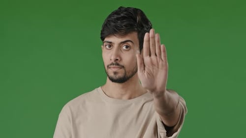Porträt Young Guy Brunet Indischer Mann ernsthaft beleidigt männliches Model steht über grünem Hintergrund Puts