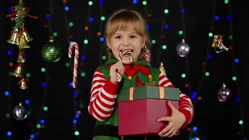 Happy Child Holding Gifts Eating Candy Cane
