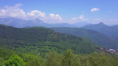 Drone Flying Over Green Trees Overlooking Mountain Peaks and Hills Covered with Forest, Highland