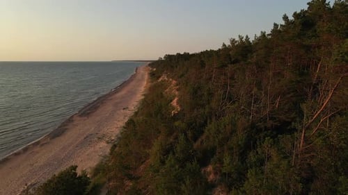 Vue aérienne : magnifique coucher de soleil sur la mer Baltique avec forêt lettone et précipice de sable