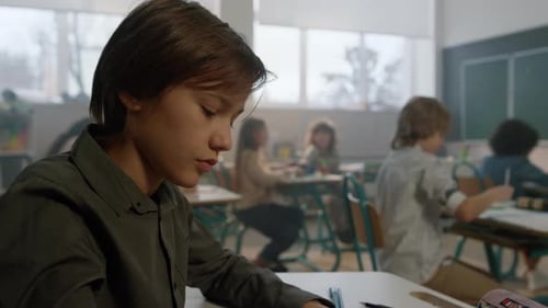 Student Studying at Desk in Bright Classroom