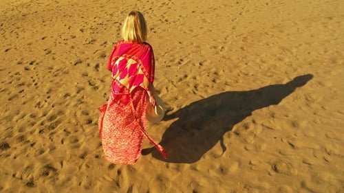 Woman Walking on Beach in Flowing Garment