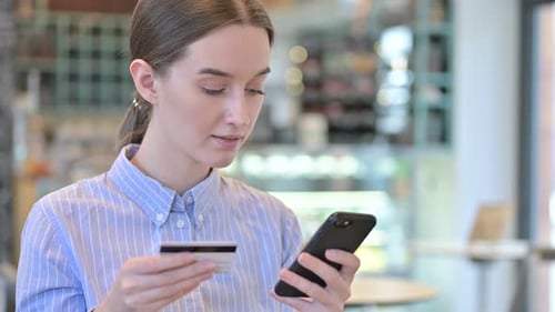 Woman Shops Online with Mobile Phone and Credit Card