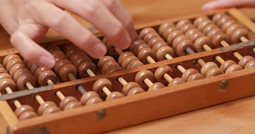 Woman Using Vintage Wooden Abacus to Calculate