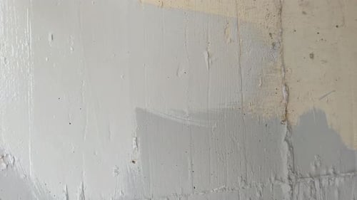Painting a Concrete Wall with a Brush Close Up