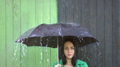 De fortes pluies se déversent sur une fille à l'abri sous un parapluie