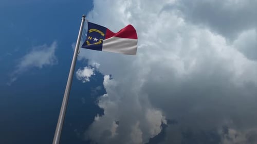 Waving North Carolina Flag on Pole Against Dynamic Clouds