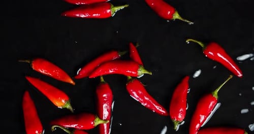 Scattered Red Chili Peppers on a Black Surface