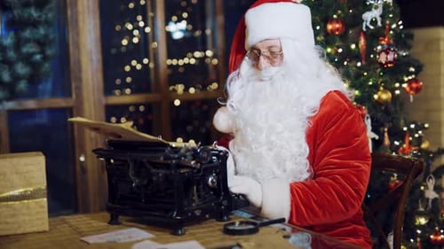 Santa Claus Typing Christmas Letters at Festive Desk