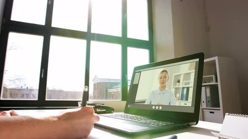 Frau mit Laptop führt Videoanruf im Büro