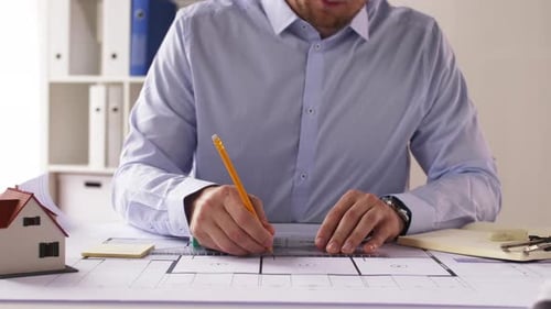 Architect with Ruler Measuring Blueprint at Office 14