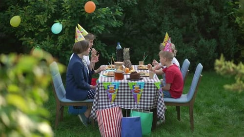 Children Celebrate Birthday in Sunny Garden Setting