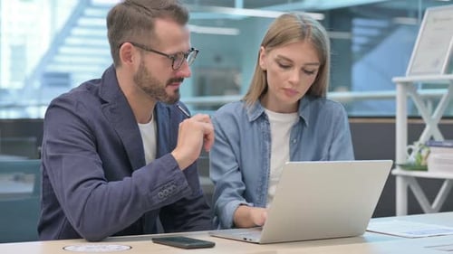Geschäftsmann und Geschäftsfrau diskutieren im Büro am Laptop