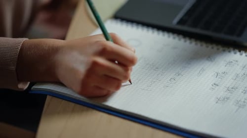 Student Hand Writing in Notebook Indoors. Unknown Girl Doing Homework Inside.