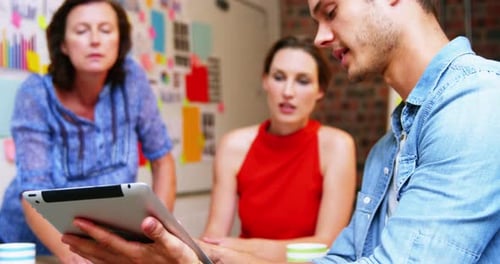 Business Team Collaborating with Tablet in Office