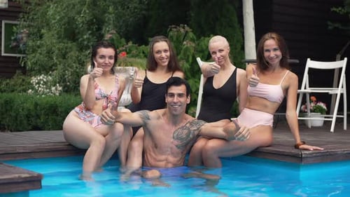 Portrait of Smiling Handsome Middle Eastern Man in Swimming Pool and Beautiful Caucasian Women at