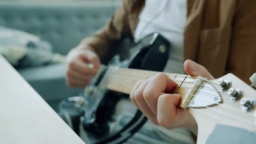 Man Playing Electric Guitar at Home in Daylight