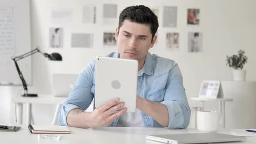 Casual Young Man Using Tablet in Office