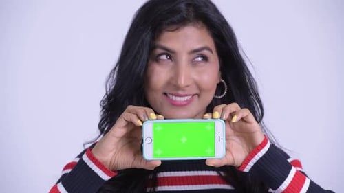 Face of Happy Young Beautiful Persian Woman Thinking While Showing Phone