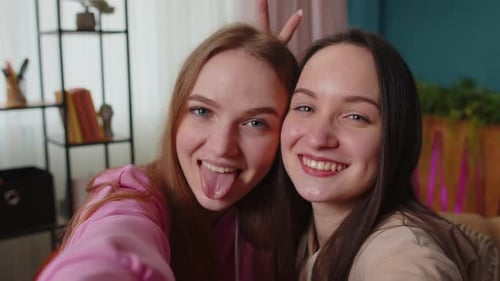 Two Young Women Take a Fun Selfie Indoors