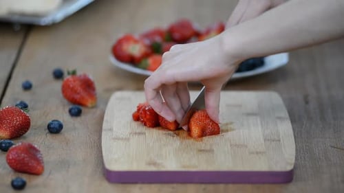 Woman Cutting Fresh Strawberries on Cutting Board