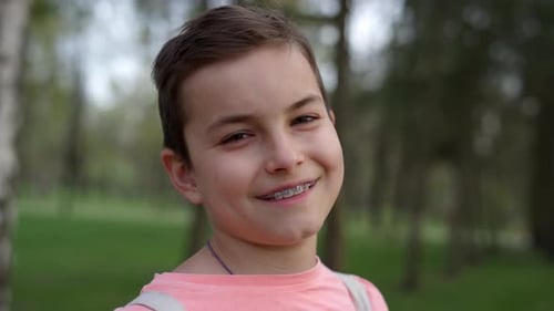 Retrato de niño alegre entre paréntesis al aire libre. Chico lindo sonriendo en el jardín.
