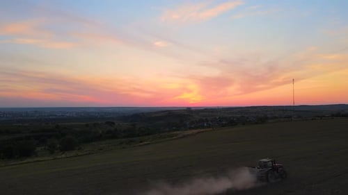 Tractor Spraying Fertilizers with Insecticide Herbicide Chemicals on Agricultural Field at Sunset