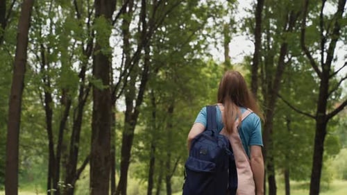 Beautiful Woman Smiles Walking Along Path Surrounded By Foliage and Trees