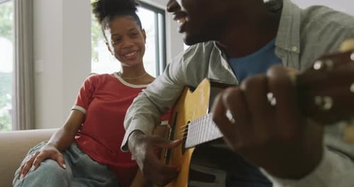 Man Plays Guitar and Sings to Woman