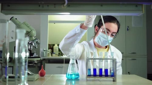 Scientist Conducting Experiment with Blue Liquid in Lab