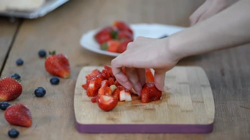 Dicing Fresh Strawberries on Cutting Board for Dessert