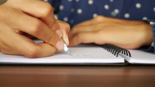 Writing in Notebook with Pen Close Up