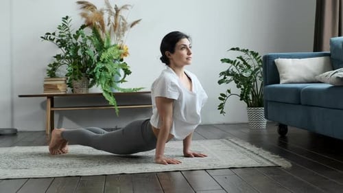 Woman Does Yoga At Home On The Rug