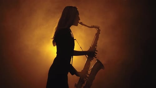 Silhouette of Woman Playing Saxophone in Golden Light