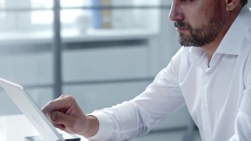 Geschäftsmann mittleren Alters tippt auf Tablet