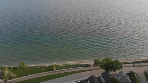 Vuelo aéreo al atardecer que muestra la costa de la isla Mackinac que muestra el carril bici costero, boardwa