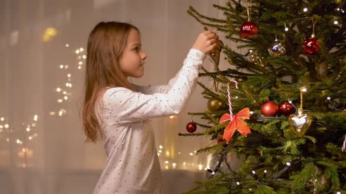Happy Girl Decorating Christmas Tree at Home 3