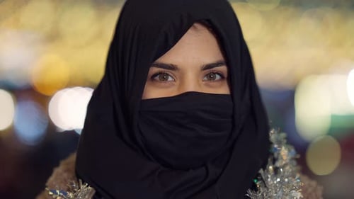 Nahaufnahme Positive Frau aus dem Nahen Osten im Kopftuch, das Gesicht bedeckt und mit haselnussbraunen Augen in die Kamera