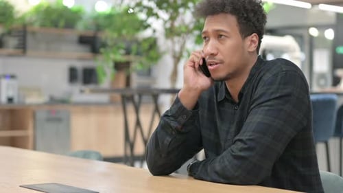 Young Adult Talking on Smartphone in Modern Office
