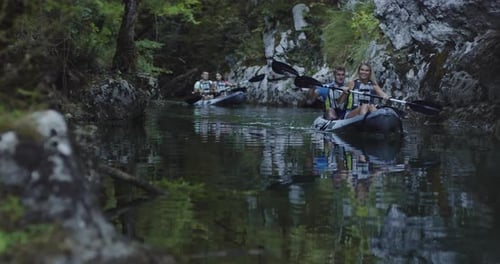 Kayakers Paddling Leisurely Down Tropical River