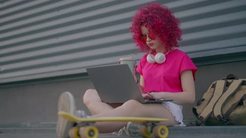 Stylish Woman Working on Laptop in Urban Setting