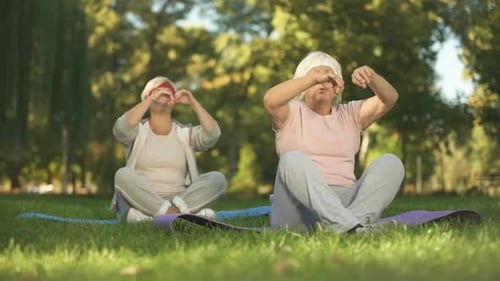 Elder Women Sitting in Lotus Position and Meditating Doing Yoga in Park, Energy