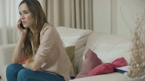 Woman Talking on Phone While Sitting on Couch